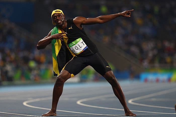 Como ya es costumbre, Usain Bolt celebra la medalla de oro en los 100 metros, con su usual gesto de victoria.
