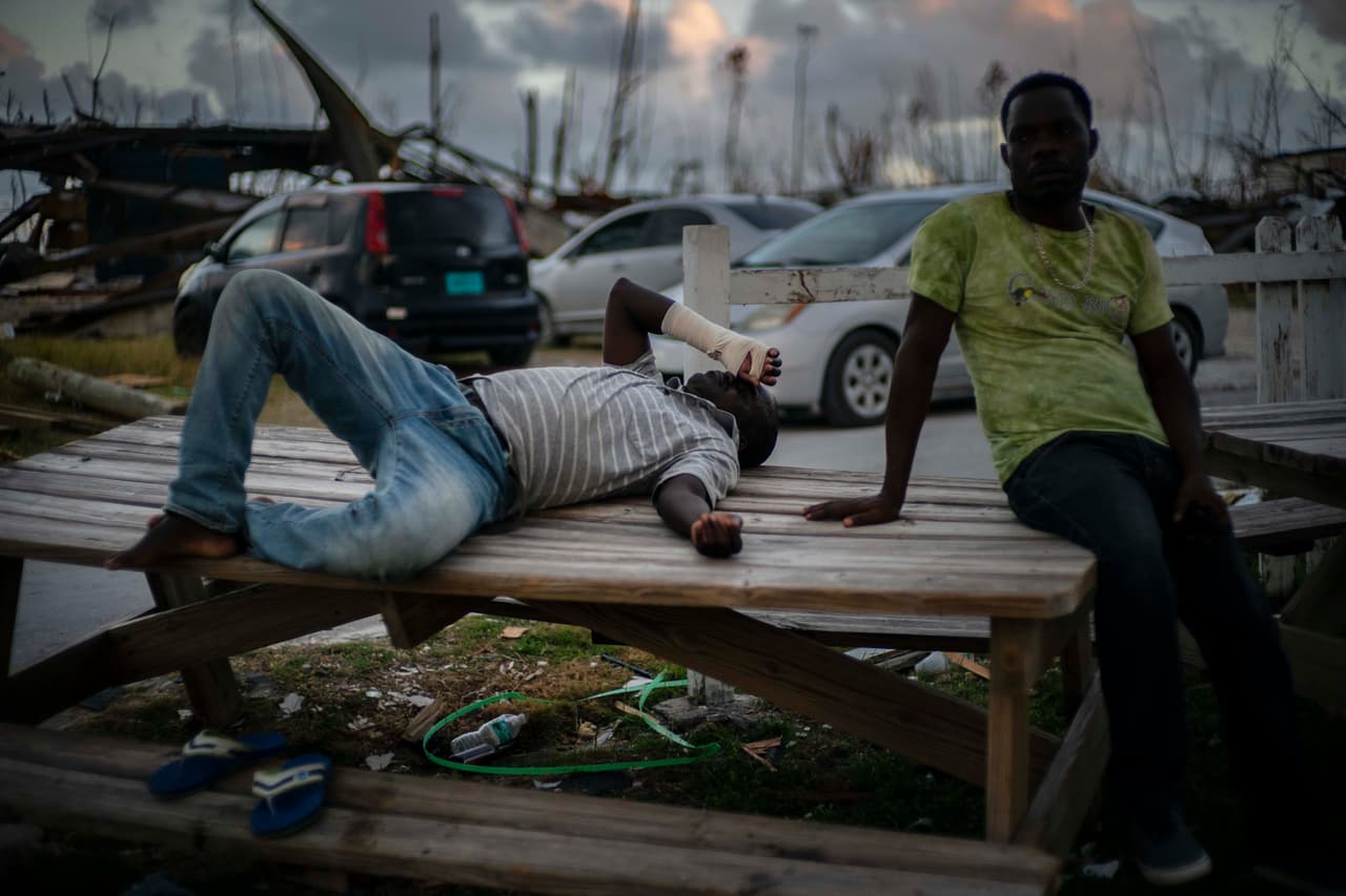 Migrantes haitianos desplazados de sus hogares destruidos por el huracán Dorian, afuera de un refugio de la iglesia en Ábaco, Bahamas, 28 de septiembre de 2019.
<br>