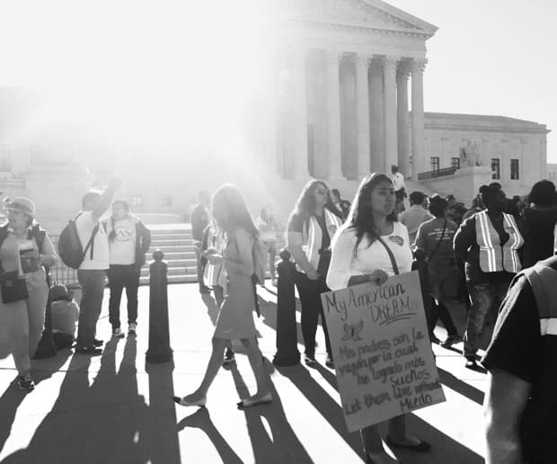 Mondragón Reyes —parada a la derecha del centro de la foto— está frente a la Corte Suprema de los EEUU con un letrero que dice: “Mi SUEÑO americano. Mis padres son las razones por las que he realizado mis sueños. Déjalos vivir sin miedo”.