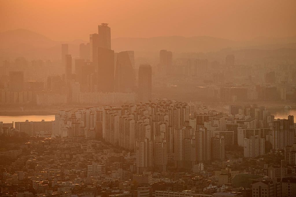 A photo taken at dusk on November 26, 2014 shows a general view of the skyline of Seoul shrouded in smog. Air quality monitors in Seoul recorded pollution levels of particulate matter 2.5 (PM 2.5) classed as 'unhealthy' on a scale defined by the US Environmental Protection Agency. AFP PHOTO / Ed Jones (Photo credit should read ED JONES/AFP/Getty Images)