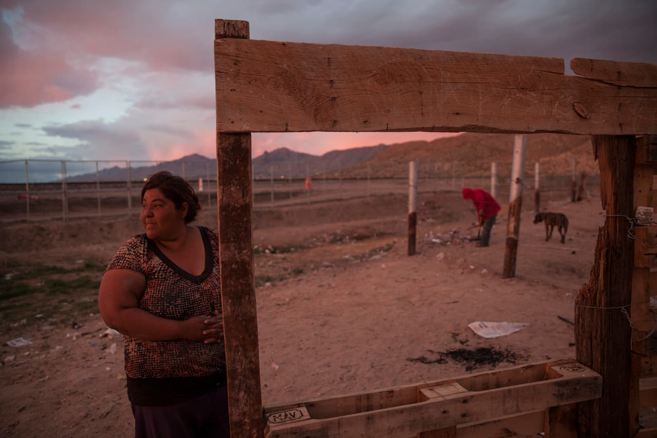 Una mujer frente al la barda que divide a México de Estados Unidos. Anapra, Ciudad Juárez, México. 29 de marzo de 2017.