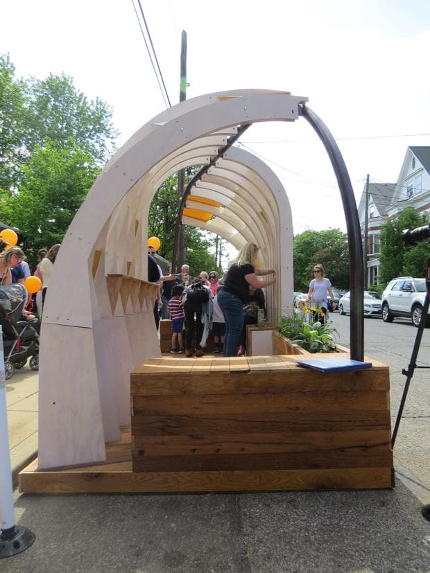 Personas cuelgan notas escritas a mano en el Wish-Igloo.