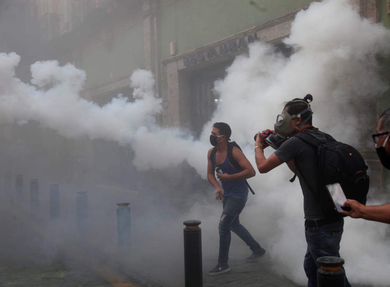 Manifestantes lanzan piedras a policías afuera del Palacio de Gobierno de Jalisco. Un policía en motocicleta embistió a un grupo de manifestantes que estaban sentados en una de las calles, quienes luego le lanzaron un objeto que le incendió la ropa. El oficial se recupera de las heridas en un hospital.