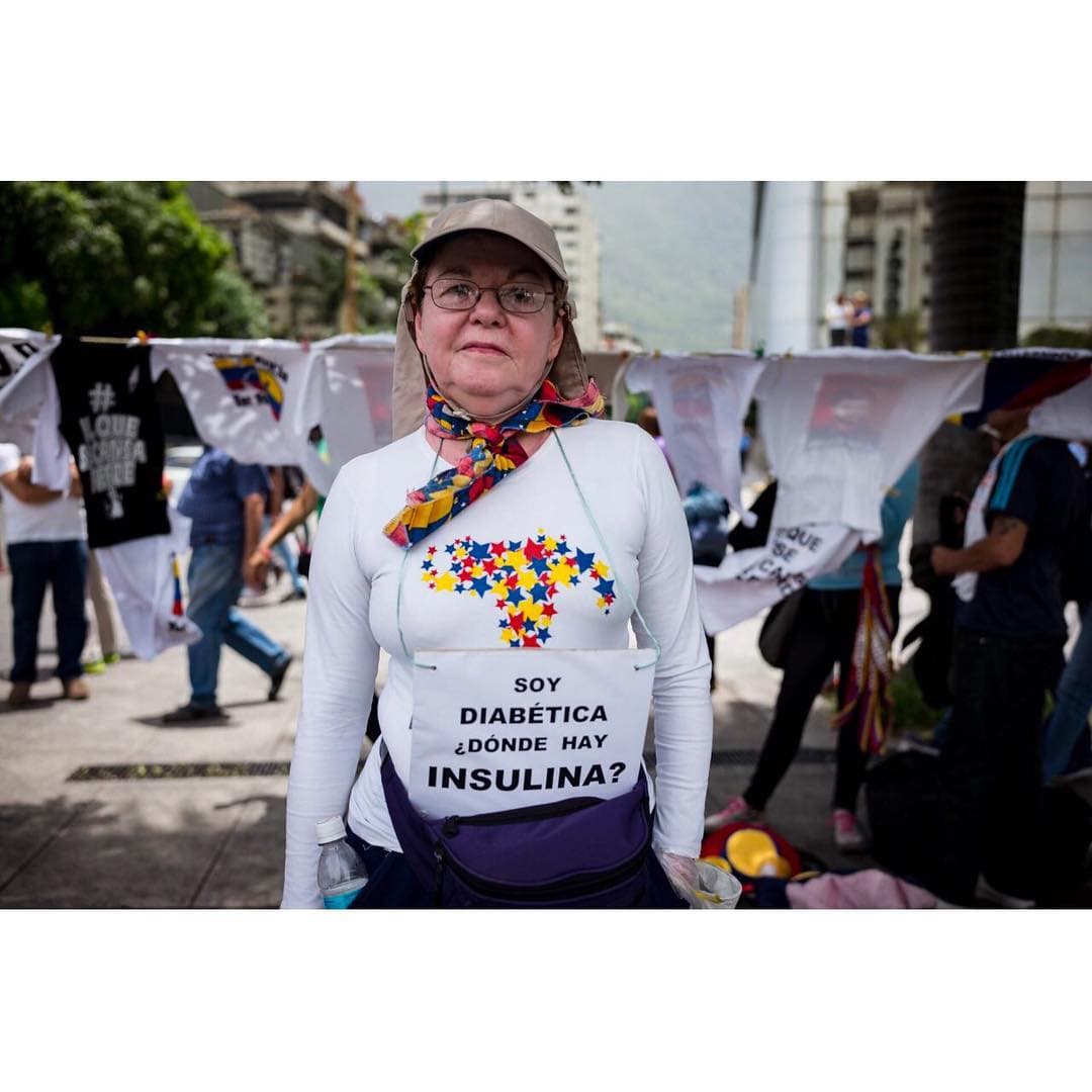 <b><a href="https://www.instagram.com/p/BUaY0gfgIoE/?taken-by=prodavinci">Mensita Garroni</a>, 69 años, paciente diabética, jubilada del Ministerio de Educación. </b>“Tengo 44 años con diabetes tipo uno y soy insulino dependiente. Esa enfermedad no tiene marcha atrás. Esto es un drama. Me están enviando la insulina de Bogotá desde hace ocho meses porque aquí no se consigue y eso que se trata de una medicina prioritaria. Me ayuda un familiar que vive allá, gracias a Dios, pero debemos pagarla en dólares. El frasco de Lantus (inyección de insulina) me cuesta seis dólares. Además debo comprar vitaminas para acompañar mi tratamiento. Vine a protestar con mi médico endocrino, él está aquí conmigo. Mi esposo lleva también un cartelito por mi hermano, que tiene Parkinson. 
<b>En la familia vivimos aterrorizados</b>. Tenemos mucho miedo de que mi hermano recaiga porque en Venezuela no hay medicinas para tratar la enfermedad. También las están enviando de Bogotá, toda la familia está abocada a que le lleguen las medicinas”. Testimonio y foto: 
<a href="https://www.instagram.com/indirapop/">Indira Rojas</a> y 
<a href="https://www.instagram.com/@aka2863">Andrés Kerese</a>.