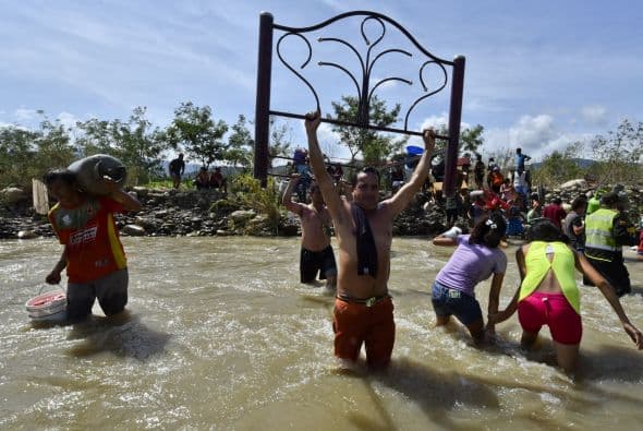 Colombianos deportados por Venezuela cargan con sus pertenencias.
