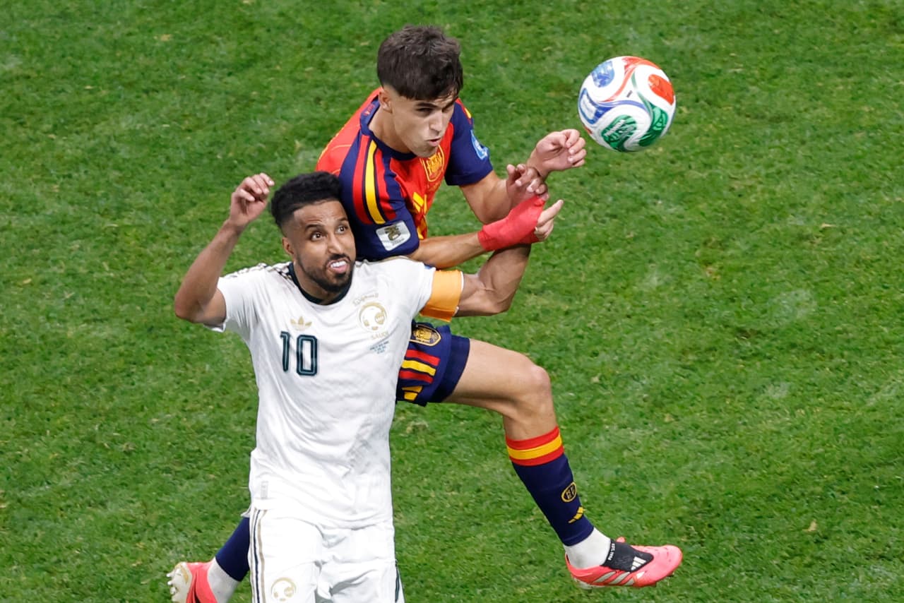 Pau Cubarsi, de España (arriba), cabecea el balón junto a Salem Aldawsari, de Arabia Saudí, durante el partido del Grupo H del Mundial