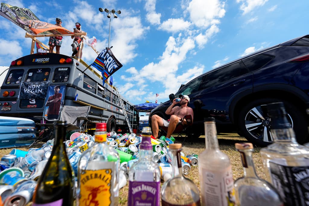 <b>Aficionados y cultura NASCAR. </b>Retratos de fanáticos con banderas, camisetas y parrillas encendidas en el infield. La imagen refleja la cultura que rodea al Daytona 500: familias, tradición y pasión multigeneracional por una carrera que cada año marca el inicio de la temporada y reúne a comunidades de todo el país.