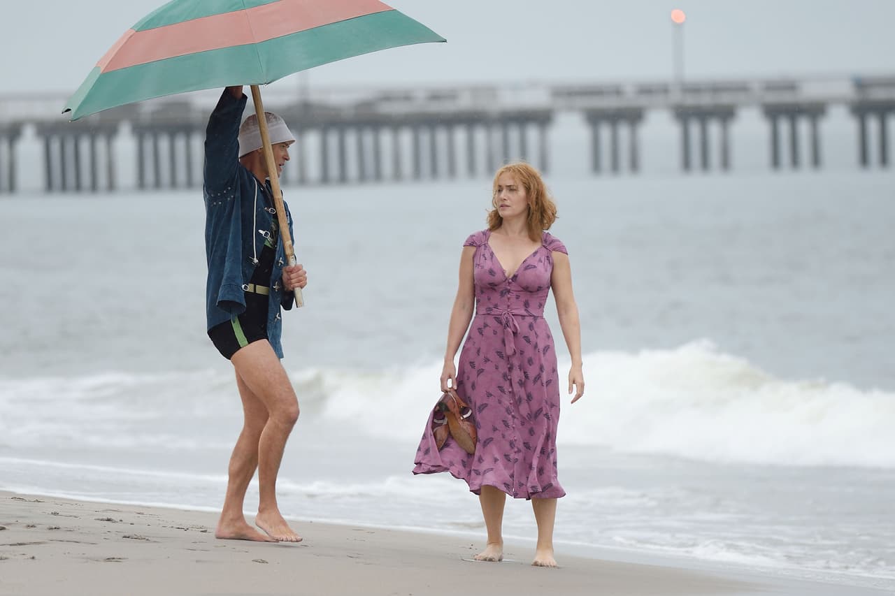 Junto cubría a su colega con una gran sombrilla.