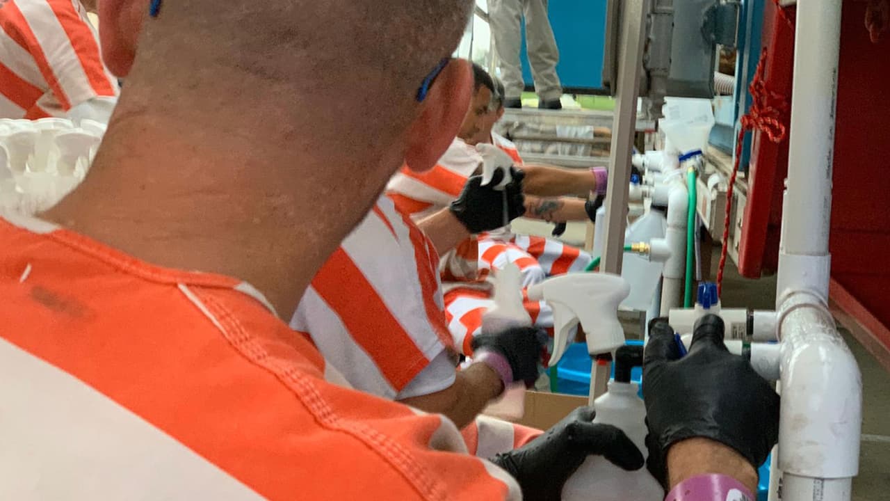 Reos de la cárcel del condado Fort Bend colaboran con el trabajo de distribución.