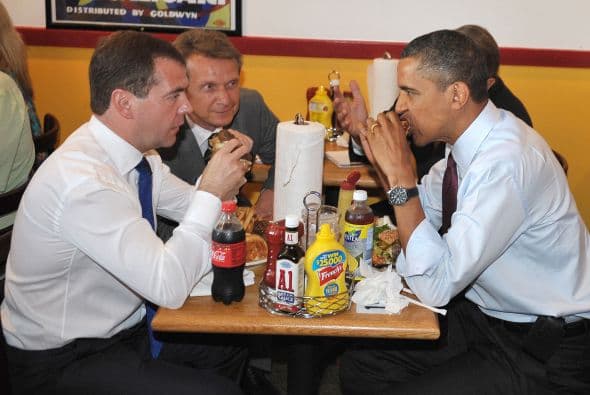 El Presidente Barack Obama y el entonces presidente de Rusia, Dmitry Medvedev, comen hamburguesas en un restaurante en Arlington, Virginia, el 24 de junio de 2010. Los acompañan sus intérpretes.