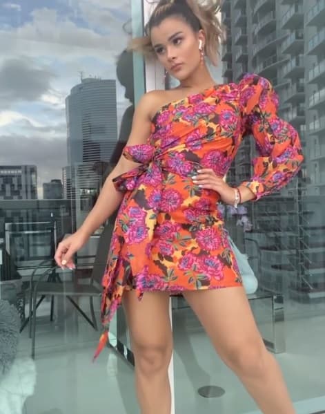 En este atuendo, Clarissa se inclinó por las flores en colores alusivos al otoño como el naranja, rosa, morado, verde y amarillo. El corte asimétrico, la manga abollonada y el lazo en la cintura que vemos en su vestido son tendencias que debes de considerar para la temporada actual.