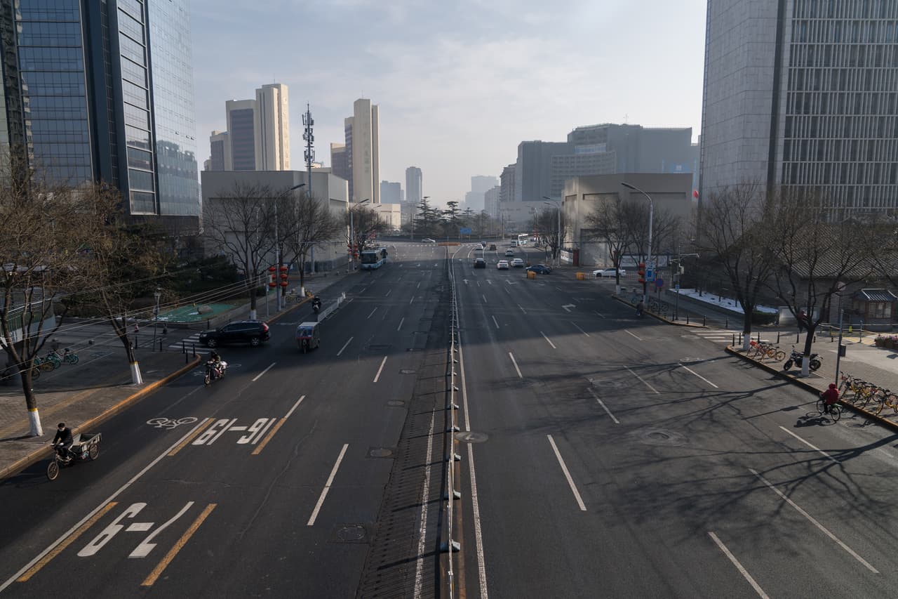 Una calle desierta de Pekín, el 10 de febrero de 2020. Según expertos las prohibiciones de viaje impedían que la fuerza laboral se incorpore a la industria, incluso fuera de Wuhan. La Organización Mundial de la Salud reconoció que recientemente hubo una "cierta estabilización" en el número de nuevos casos de coronavirus, pero dijo que es demasiado pronto para saber si el brote ha llegado a su máximo nivel.