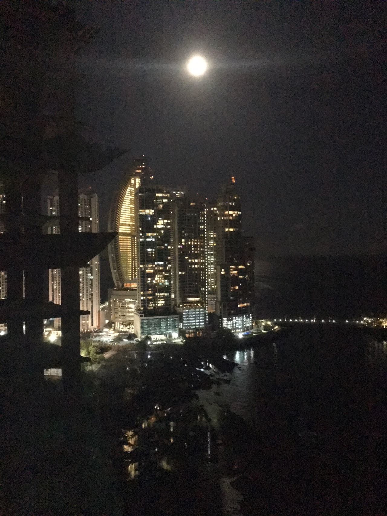 Moon rising over the Trump Ocean Club International Hotel & Tower (on left with lights).