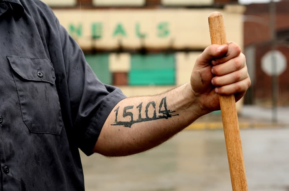 ** ADVANCE FOR SUNDAY APRIL 22 ** Braddock, Pa., Mayor John Fetterman, with the city's zip code tattooed on his arm, stands in an alley behind the main street of Braddock, Saturday, March 10, 2007. At 6-foot-8, 300 pounds, the 37-year old Harvard-educated mayor is making a big impression on Braddock, one of the few townspeople with an imagination vivid enough to envision the turnabout of a decaying milltown in the Rust Belt. (AP Photo/Andrew Rush)