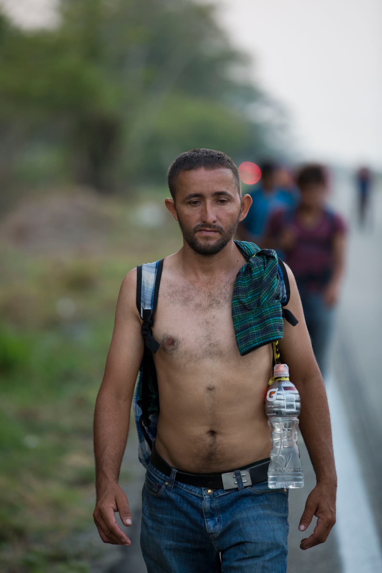 Un migrante centroamericano camina por la carretera a Pijijiapan, México, este lunes 22 de abril.
<b> La ayuda que recibieron las anteriores caravanas ha ido mermando. Reporteros que viajan con ellos dicen que este enorme grupo viaja hambriento y es acosado por funcionarios locales.</b>