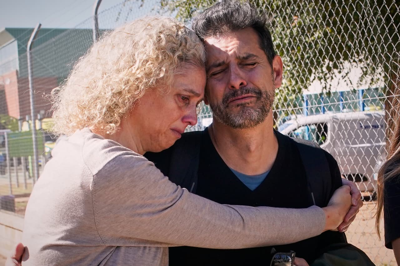 Dos pasajeros se abrazan tras su rescate.