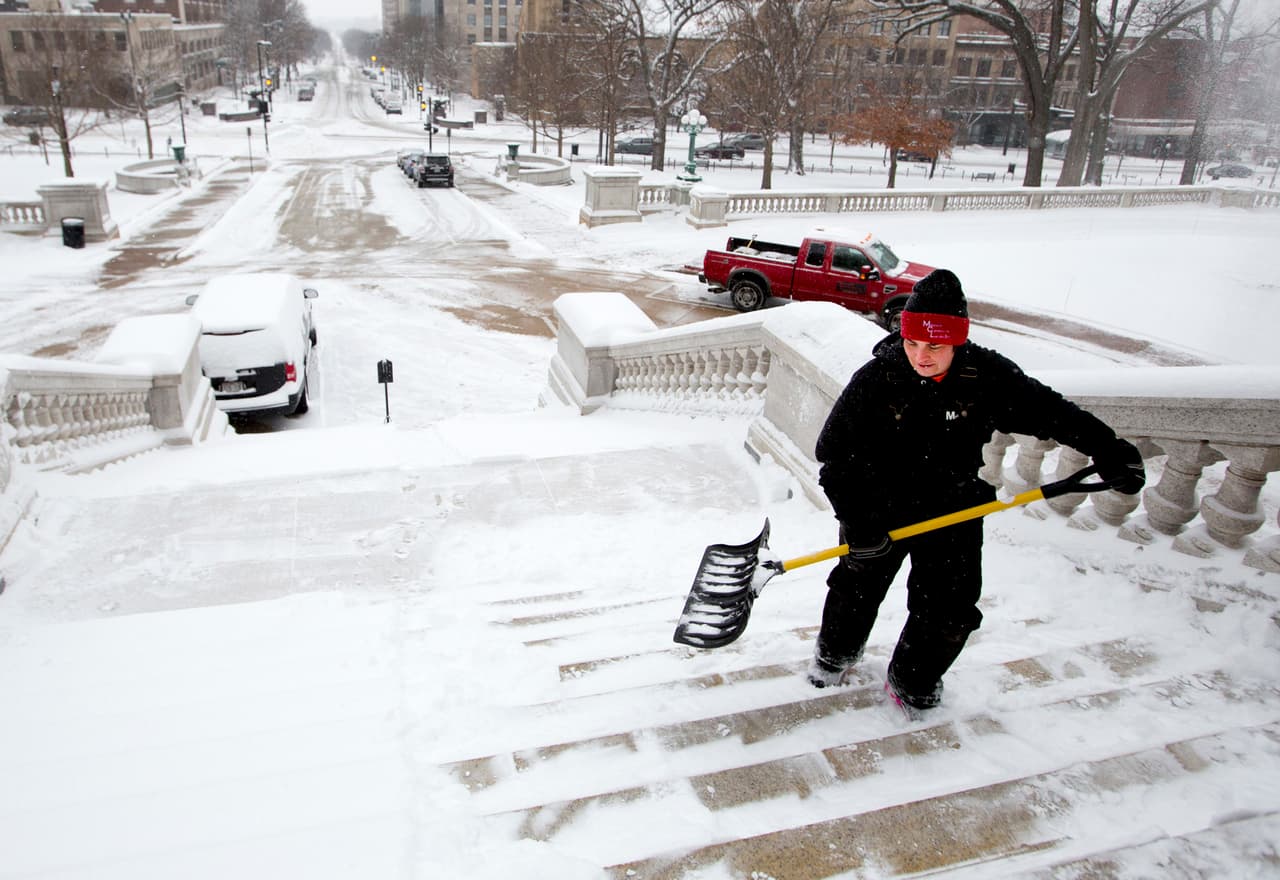 Una mujer limpia las escaleras del capitolio del estado de Wisconsin.