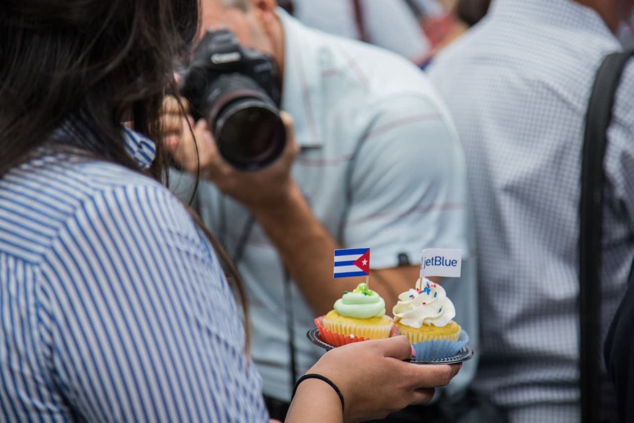 Un fotógrafo intenta captar una imagen de dos pastelitos conmemorativos del vuelo. El evento de lanzamiento anterior al vuelo reunió música en vivo, comida y una abundante parafernalia con referencia a Cuba.
<br>