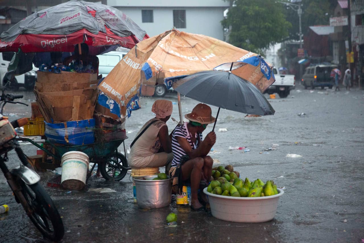 Vendedores ambulantes en las calles de Puerto Prince en Haití se protegen de las lluvias causadas por Laura.
<br>
<br>En Haití, al menos cinco personas murieron en Haití este domingo por las lluvias torrenciales y deslizamientos de tierras causados por la tormenta tropical Laura, según un nuevo balance parcial de la Dirección de Protección Civil.