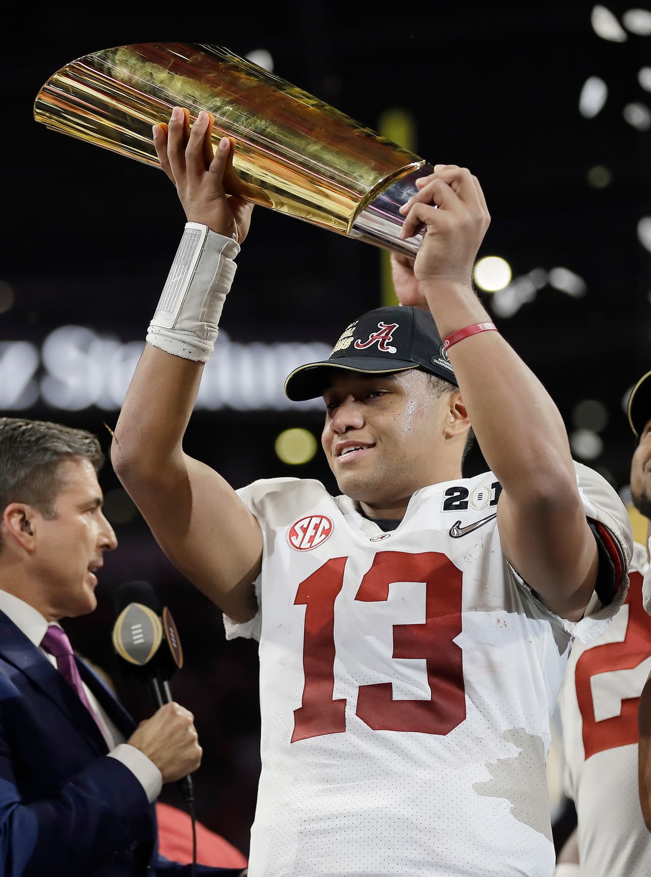 Alabama's Tua Tagovailoa holds up the championship trophy after overtime of the NCAA college football playoff championship game against Georgia, Monday, Jan. 8, 2018, in Atlanta. Alabama won 26-23. (AP Photo/David J. Phillip)
