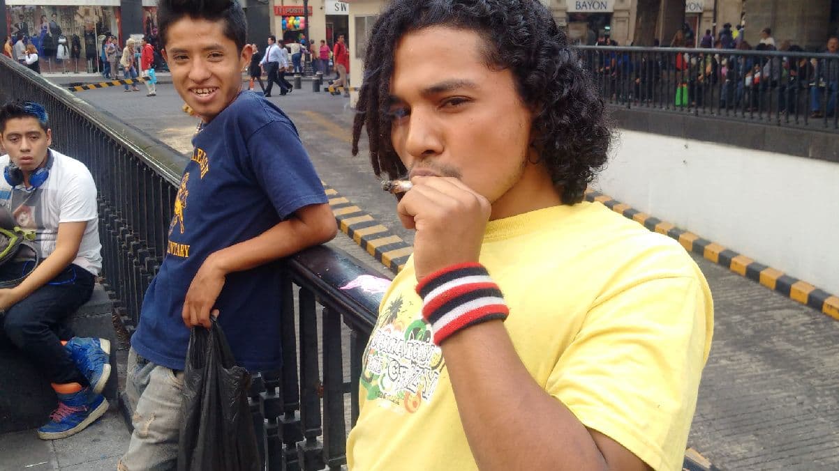 Un joven fumando marihuana afuera de la Suprema Corte.