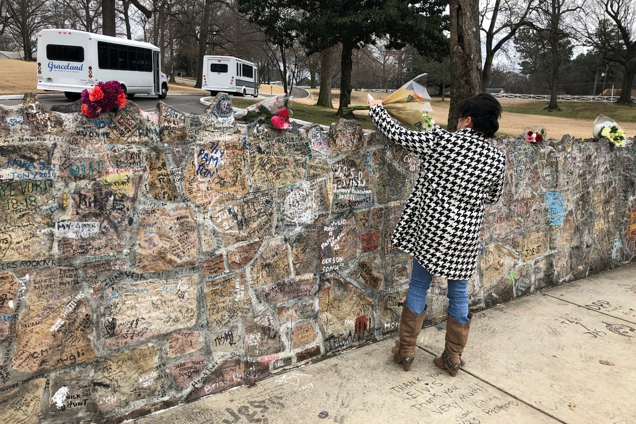 Una admiradora coloca un ramo de flores sobre una pared de Graceland, el 13 de enero de 2023 en Memphis, Tenneseee. Los admiradores rindieron homenaje a Lisa Marie desde que se conoció su muerte. Dejaron flores y compartieron memorias sobre la única descendiente de Elvis Presley.