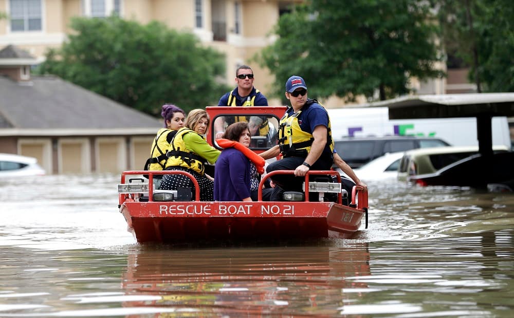 Un grupo de ciudadanos son evacuados por las autoridades en una embarcación.