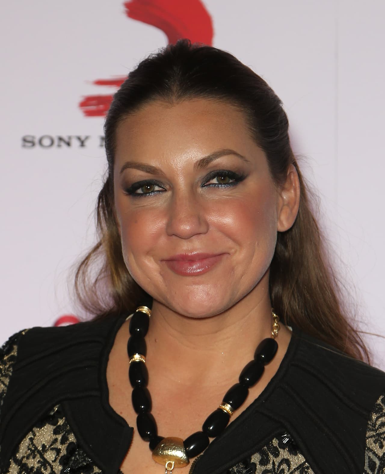 Las miradas iban directo a su collar con cuentas negras y detalles de plumas.