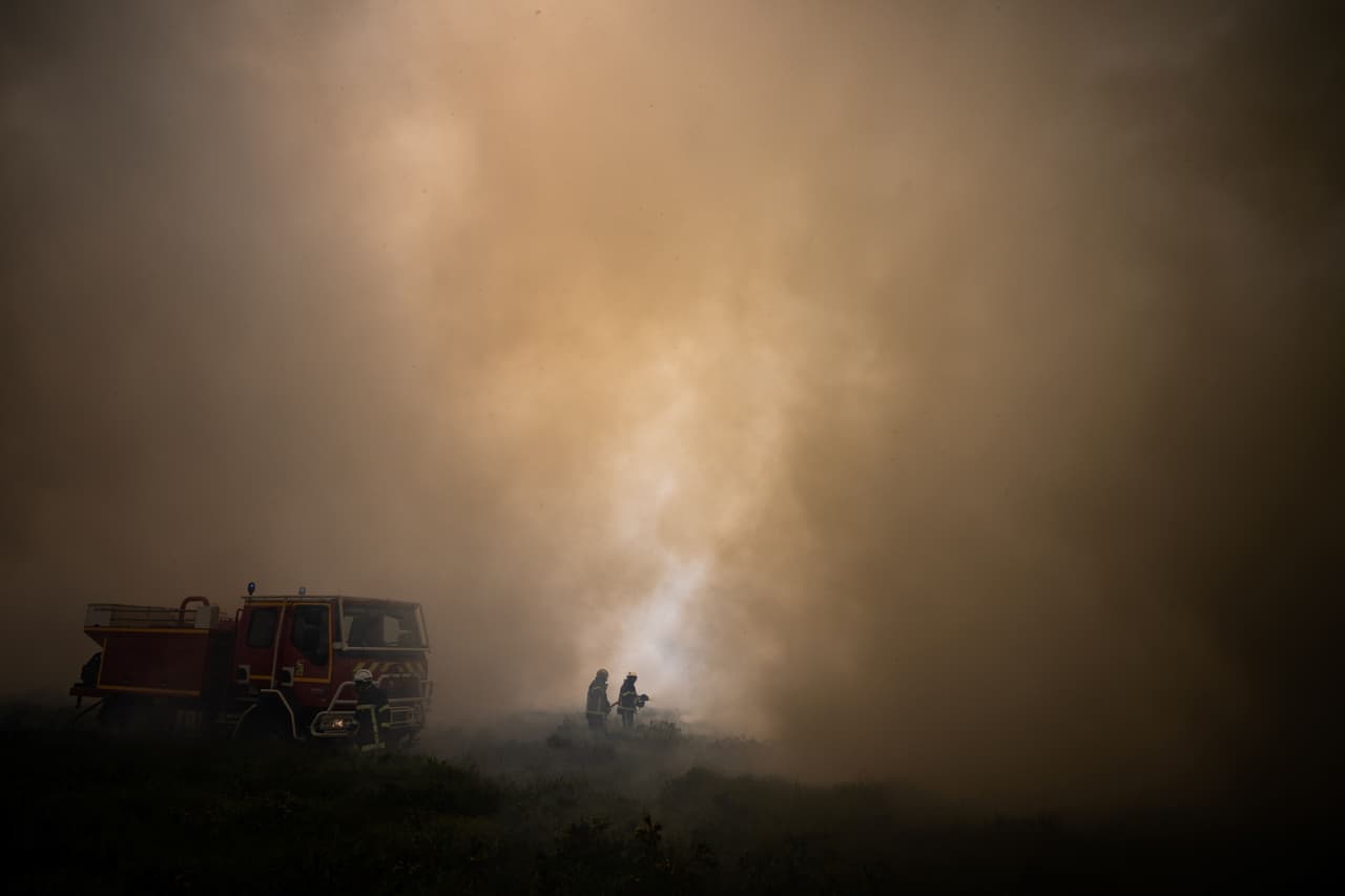 Bomberos intentan controlar el fuego en Monts d'Arree, cerca de Brasparts, Bretaña, Francia. En la región de Gironde, en el suroeste de Francia, los feroces incendios forestales continuaron propagándose a través de bosques de pinos secos como yesca, lo que frustró los esfuerzos de más de 2,000 bomberos y aviones que bombardeaban agua.