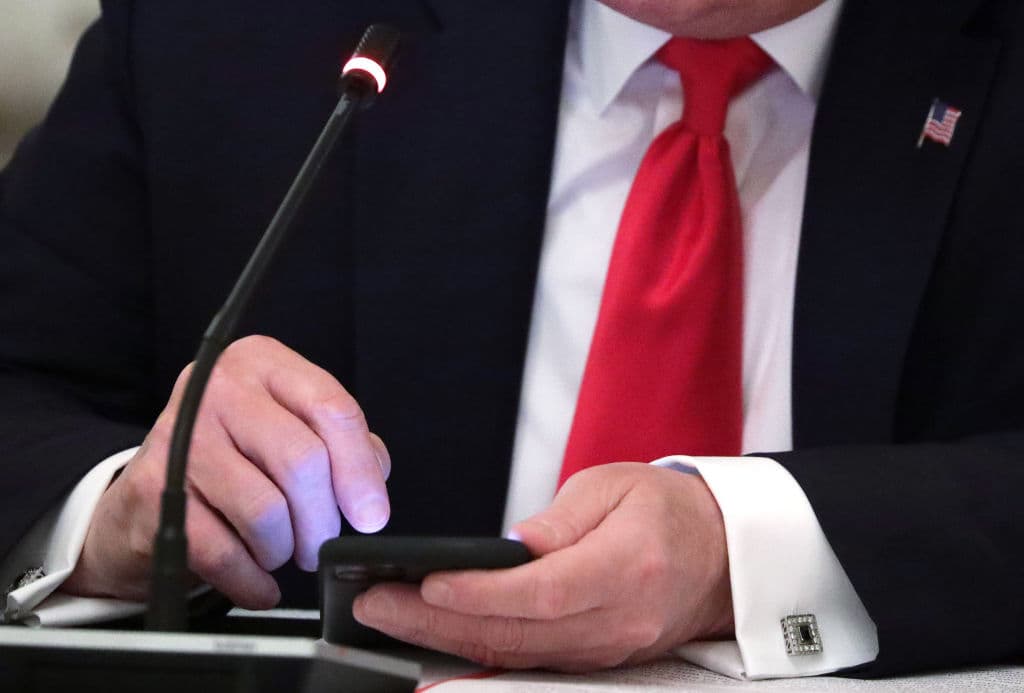 El presidente Donald Trump mira su teléfono durante una mesa redonda con los gobernadores sobre la reapertura de las pequeñas empresas de Estados Unidos, en el Comedor del Estado de la Casa Blanca, el jueves 18 de junio de 2020 en Washington.