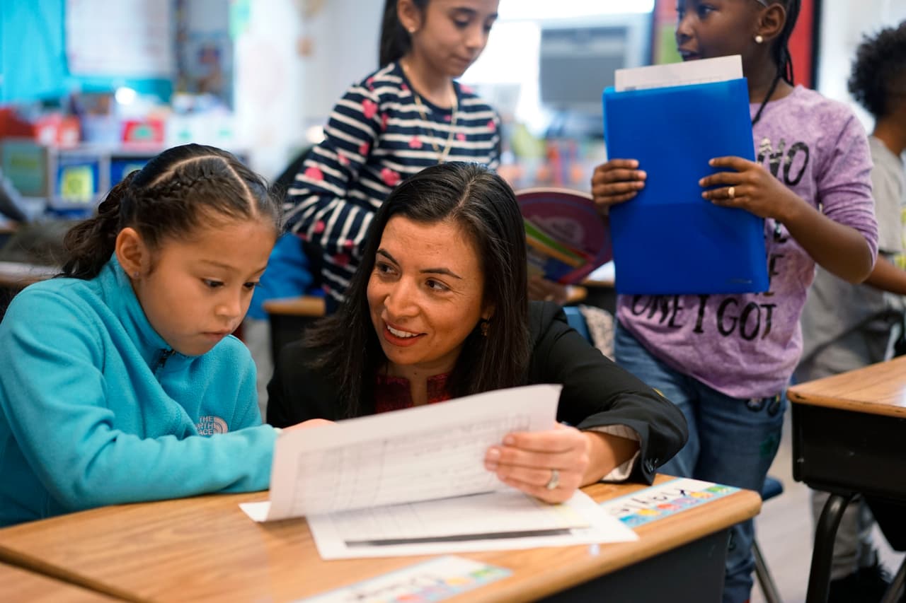 Daniela Anello, Head of School at the DC Bilingual Public Charter School checks in with third grader Kayley Diego, 9, on Thursday Nov. 16, 2017 in Washington D.C.