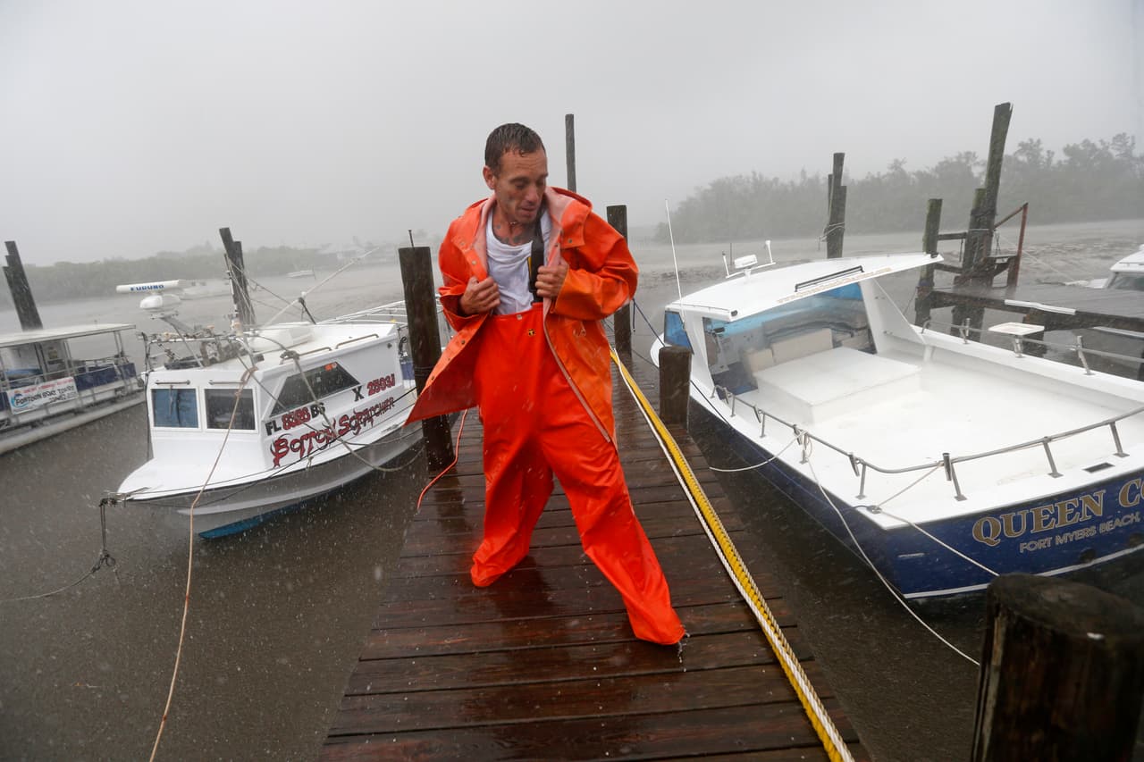PJ Pike revisa su barco, a la izquierda de la imagen. Los barcos están fijados con sus amarres en el barro debido a una marea inusualmente baja. Se trata de los primeros efectos del huracán Irma en Fort Myers, Florida, este domingo. El área de Fort Myers se está preparando para una posible tormenta catastrófica.