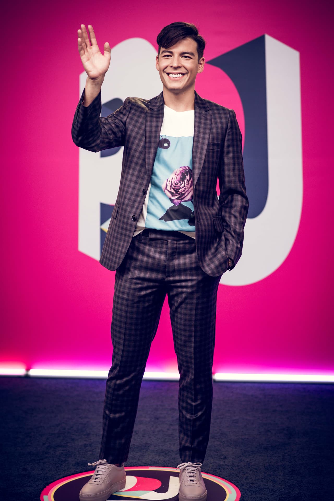 Manolo González desfiló muy sonriente con un look casual. El presentador de los Premios Juventud 2018 lució un traje morado cuadriculado y playera estampada.