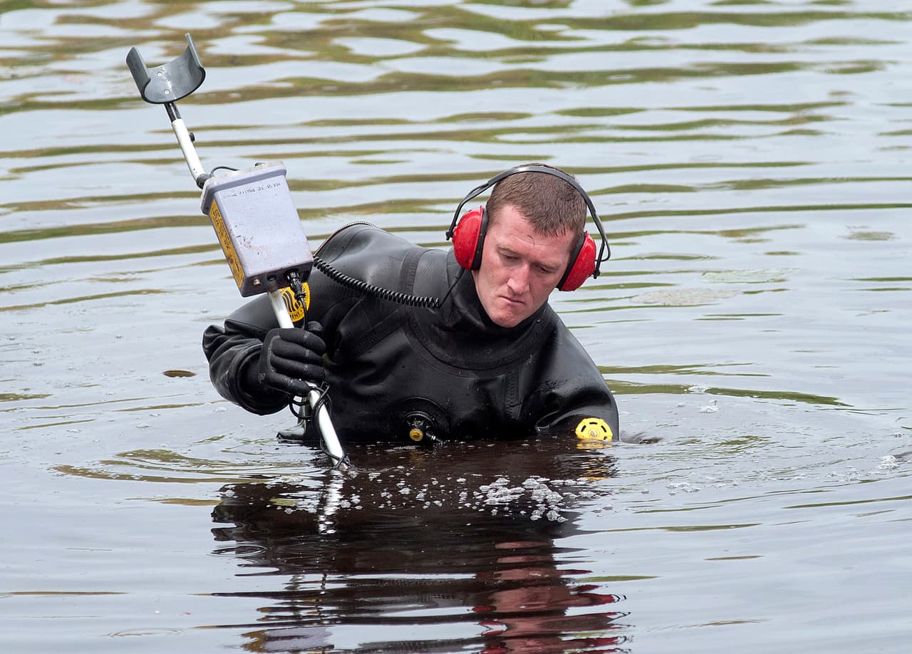 Buzos trabajando en el estanque cercano al lugar del crimen.