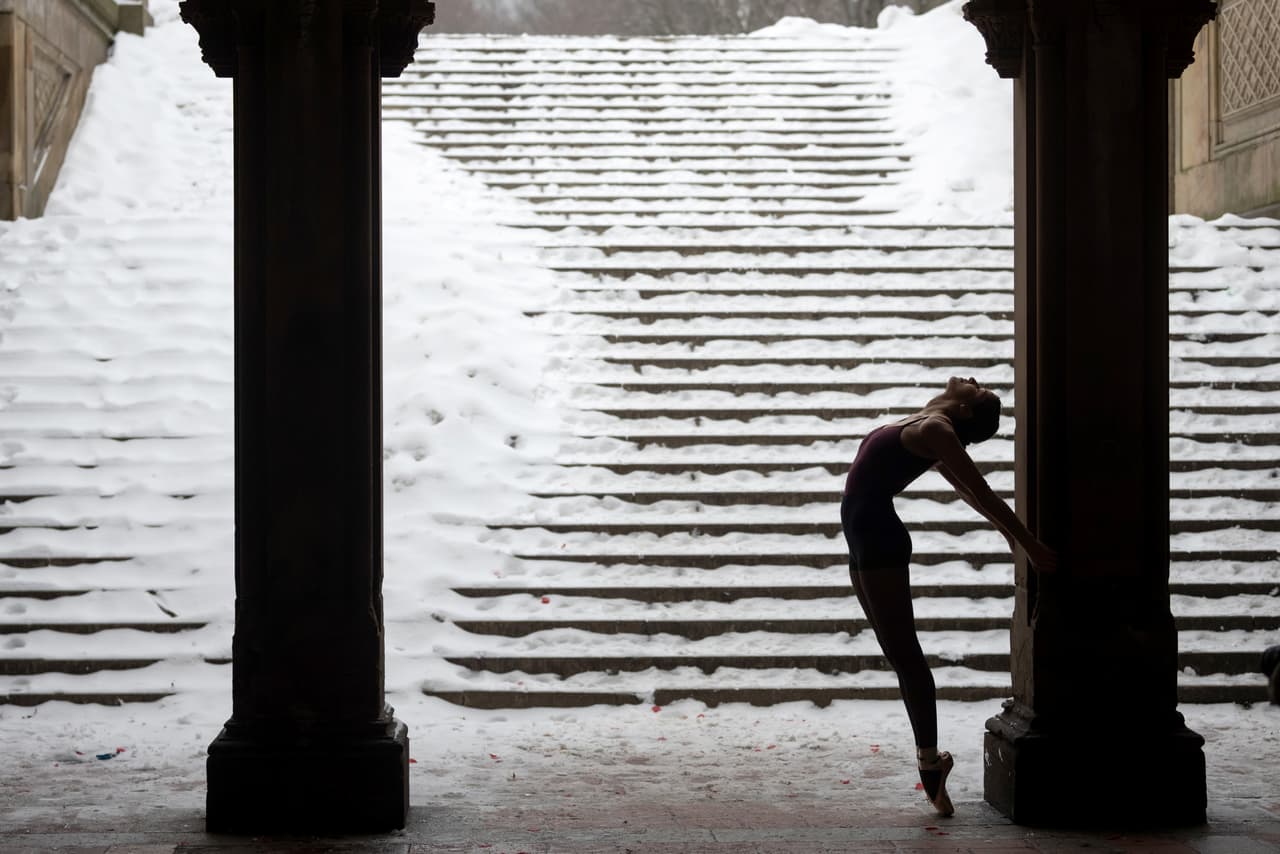 Una bailarina en punta posa bajo la terraza de Bethesda durante una tormenta de nieve en Central Park