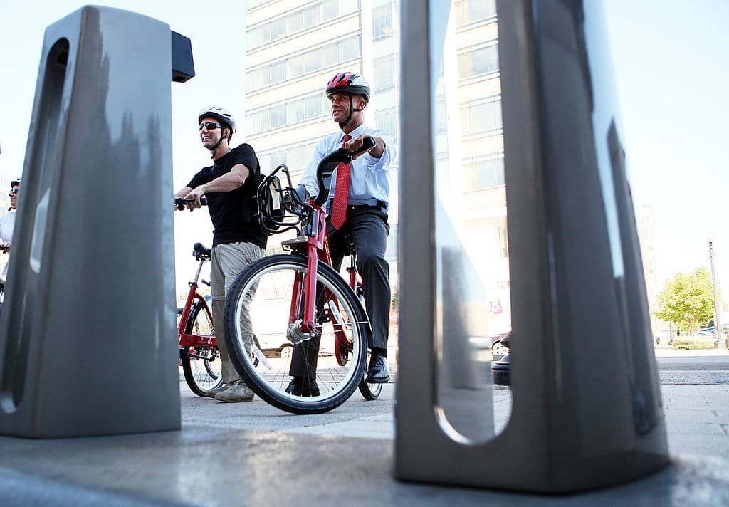 WASHINGTON - SEPTEMBER 20: D.C. Mayor Adrian Fenty (R) about to check-in his bike at a station as he rides on a bike for a media photo-op during the launching of the Capital Bikeshare program September 20, 2010 in Washington, DC. The program, the largest bike-sharing system in the U.S., will put 1,100 bicycles in more than 100 stations across DC and Arlington, Virginia. (Photo by Alex Wong/Getty Images)
