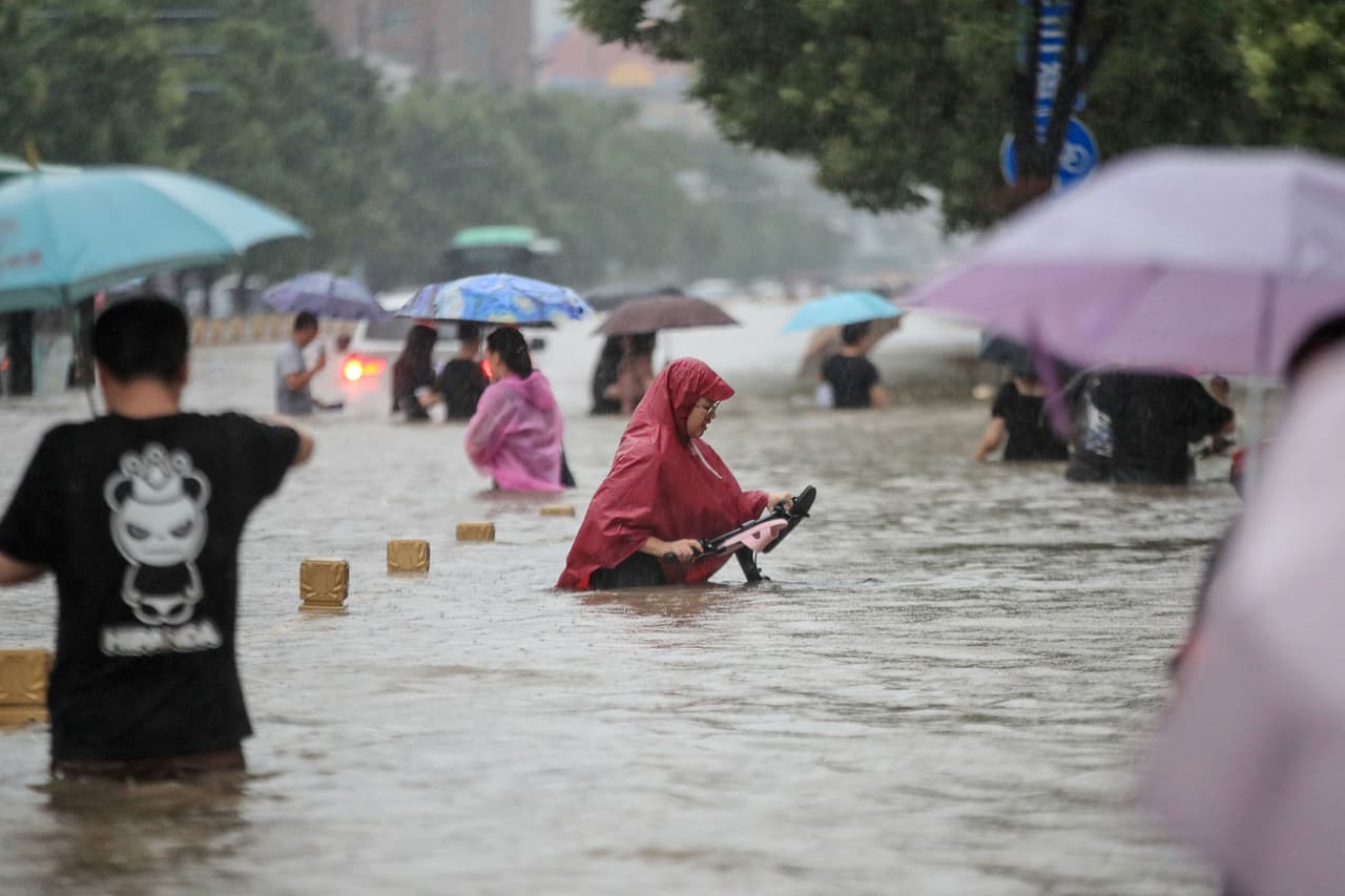 Gente caminando con el agua hasta la cintura con una calle de Zhengzhou. Las inundaciones son comunes en esta época del año pero la tormenta que ha caído durante tres días consecutivos marca registros históricos, con 45.7 centímetros de agua acumulada.