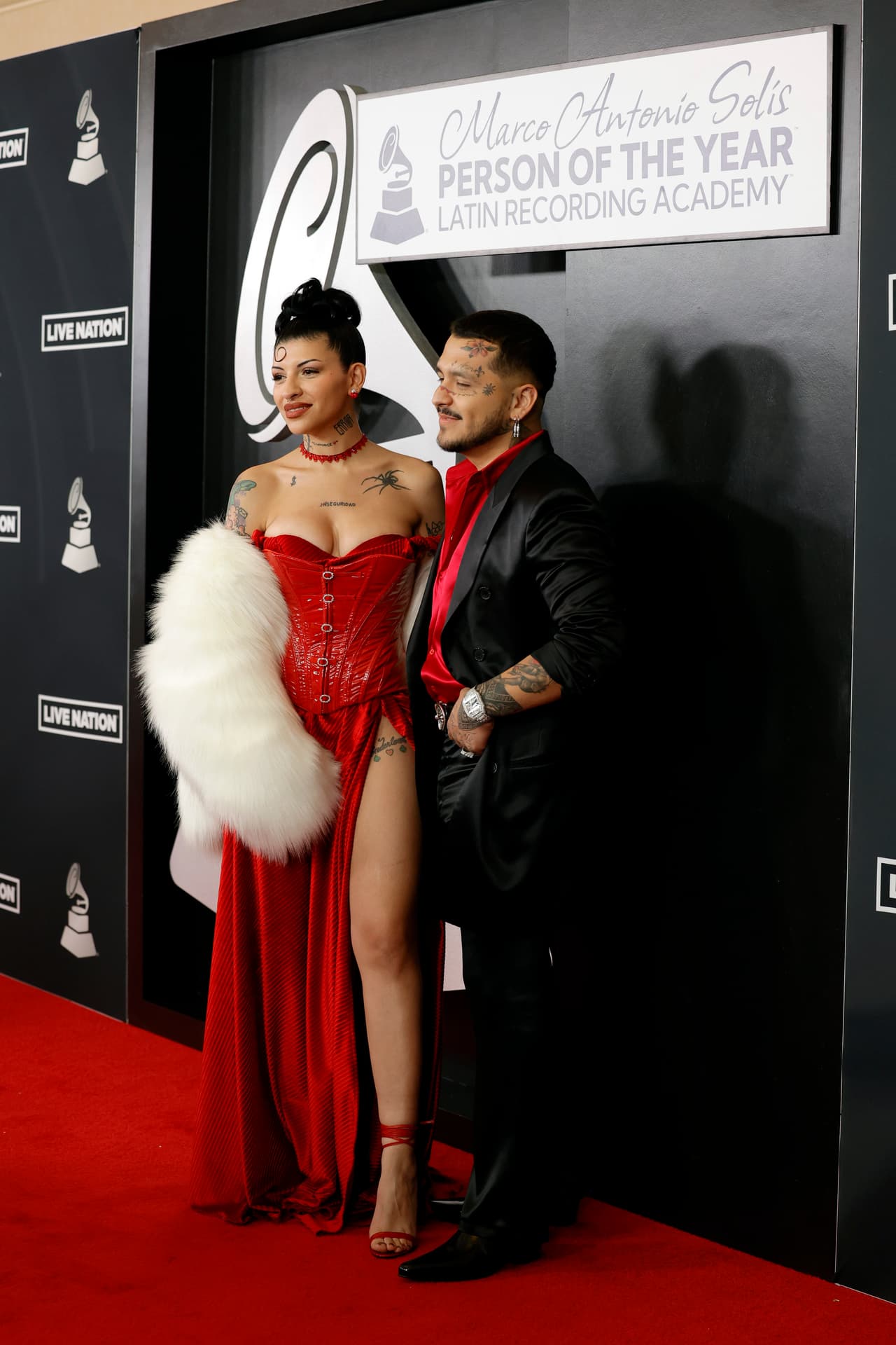 Por su parte, Christian Nodal lució un elegante traje satinado en negro, que combinó con una camisa roja de la misma tela. Reloj y aretes plateados fueron los accesorios con los que complementó su atuendo.