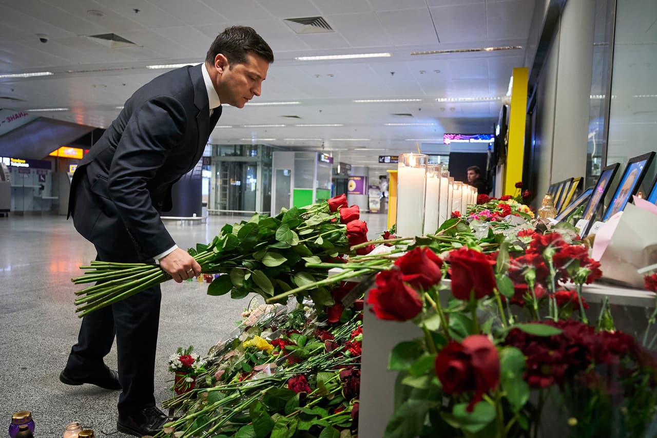 El presidente de Ucrania, Volodymyr Zelenskiy, deja flores en un altar puesto en el aeropuerto de Kiev en honor a las víctimas del accidente aéreo del miércoles en Irán.