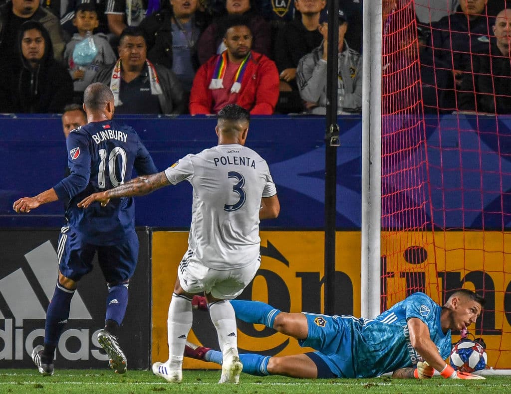 Al minuto 60' Teal Bunbury (izquierda) marcó el 2-0 para New England luego que el balón se fuera debajo del cuerpo del arquero David Bingham (derecha).