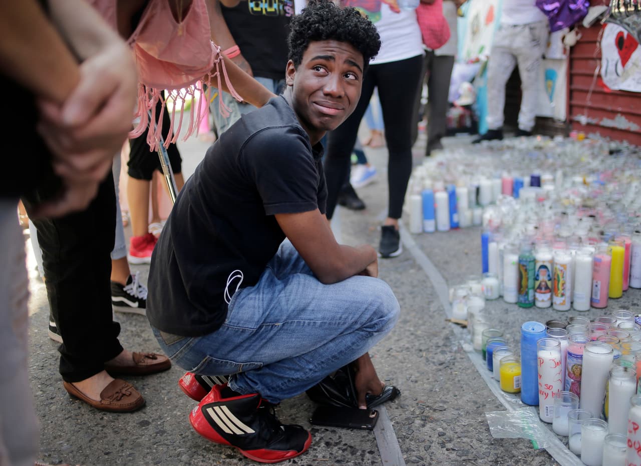 Asistentes lloran frente al monumento conmemorativo a Lesandro Guzmán-Feliz cerca del sitio de su asesinato en el Bronx, ciudad de Nueva York, el lunes 25 de junio de 2018. La pandilla los Trinitarios ha sido acusada de su asesinato a machetazos