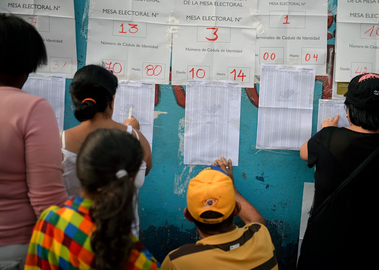 Votantes buscan sus nombres en un centro de votación ubicado en Petare, Caracas.