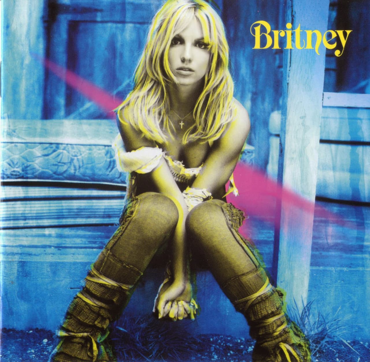 Una Britney Spears seria, recargada sobre sus rodillas y con colores chillantes se dejan ver en el disco homónimo de la cantante. Foto: Jive Records.