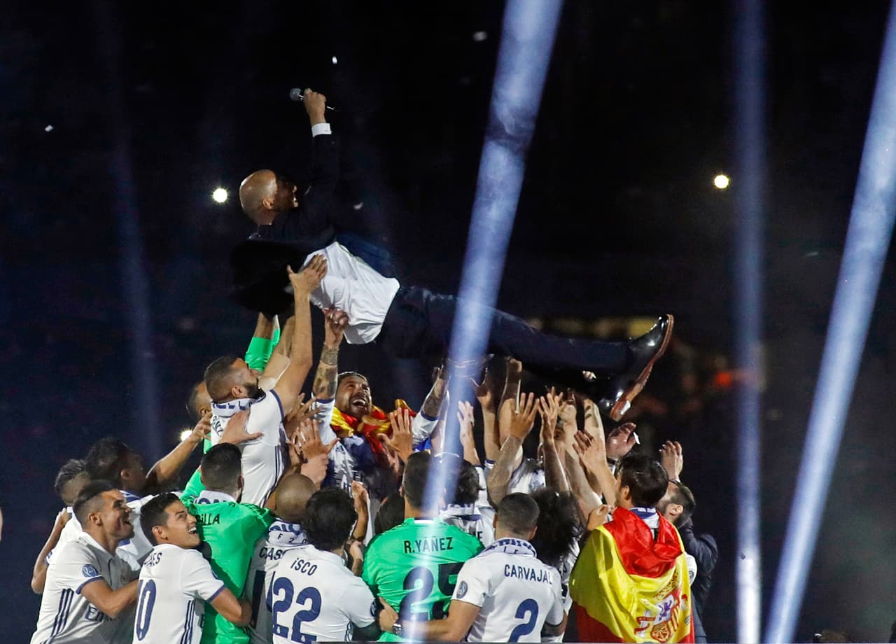Real Madrid's French coach Zinedine Zidane is tossed by players as they celebrate the team's win, at the Santiago Bernabeu stadium in Madrid on June 4, 2017 after winning the UEFA Champions League football match final Juventus vs Real Madrid CF held at the National Stadium of Wales in Cardiff on June 3, 2017. / AFP PHOTO / Oscar DEL POZO (Photo credit should read OSCAR DEL POZO/AFP/Getty Images)