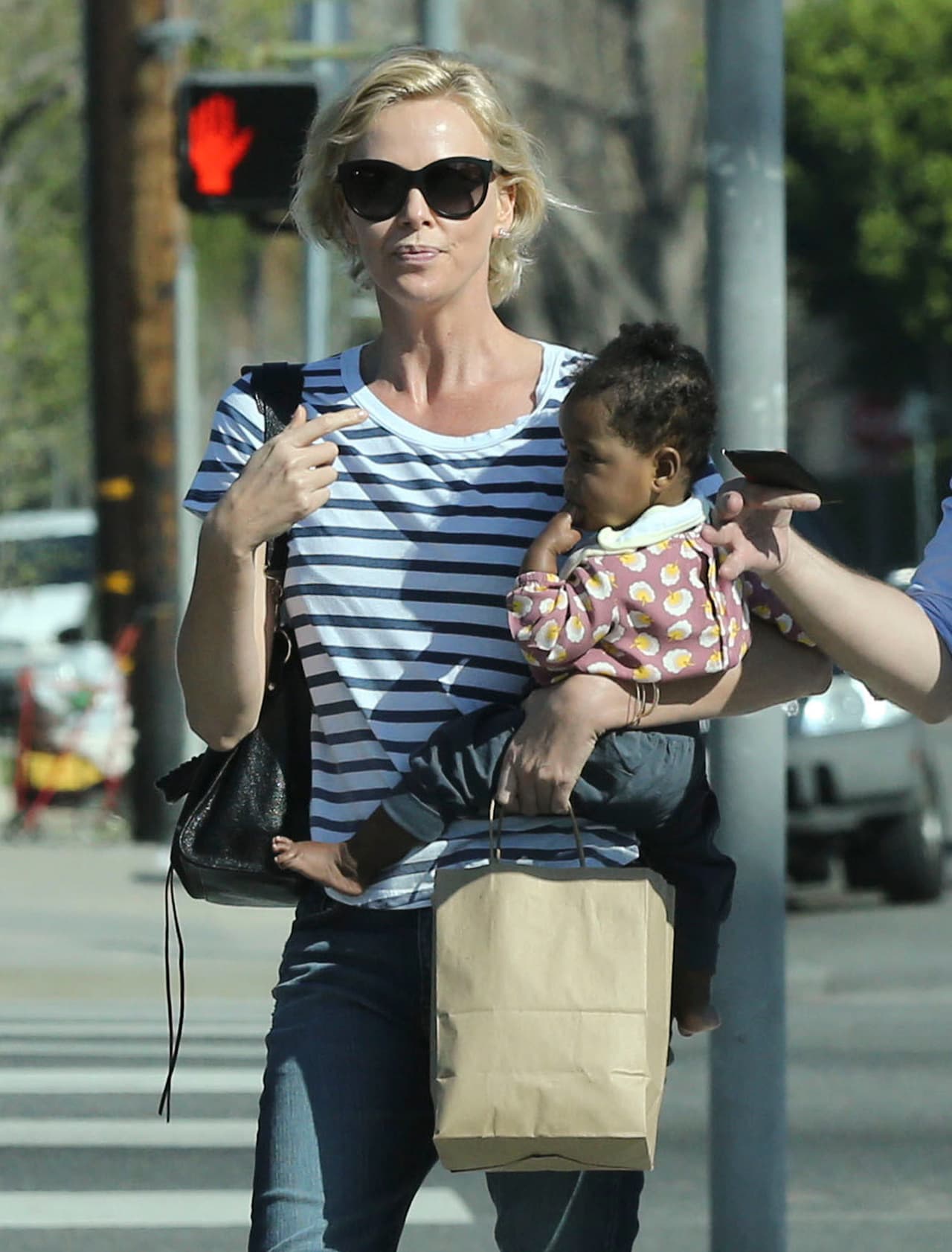 Charlize estuvo muy sonriente, cargando a su nena August.
