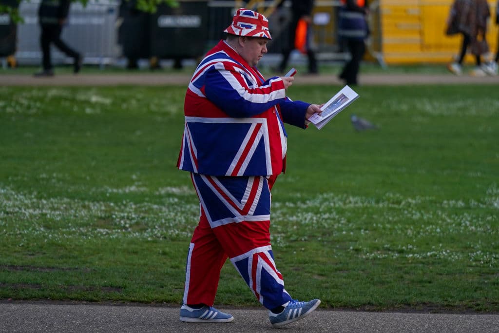 Un hombre que acampa en la zona para ser testigo del desfile lleva un traje de la Union Jack.