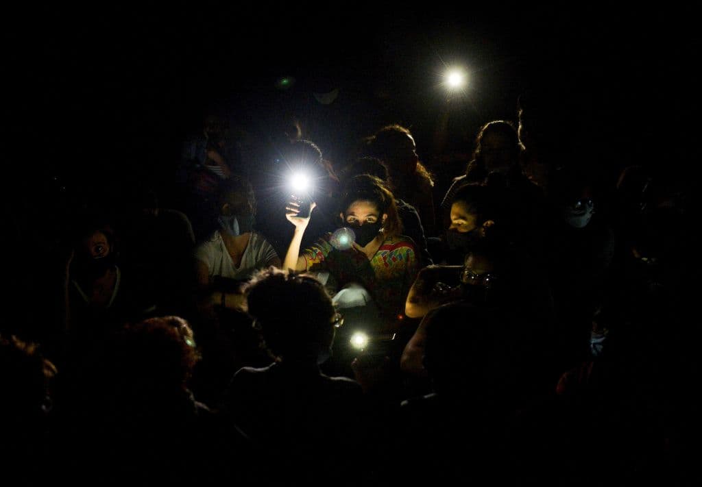 A group of young intellectuals and artists hold up lights on their mobile phones as they demonstrate at the doors of the Ministry of Culture during a protest in Havana, early on November 28, 2020.
