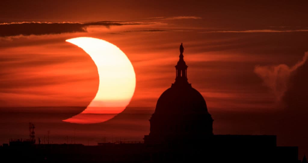 En esta imagen proporcionada por la NASA, se ve un eclipse solar parcial cuando el sol sale detrás del Capitolio el 10 de junio de 2021 en Arlington, Virginia.