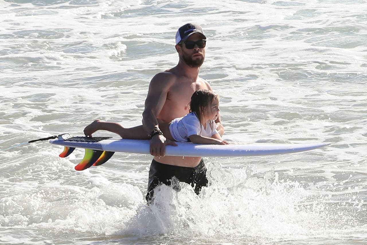 El protagonista de 'Thor' subió a uno de sus pequeñines a su tabla de surf. ¿Será que lo quiere iniciar en este intrépido deporte?
