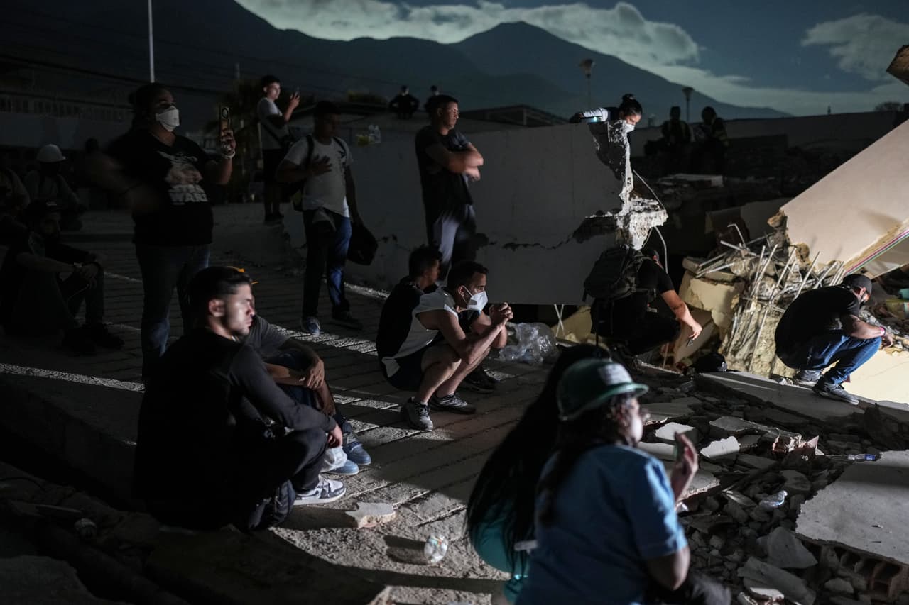 Residentes de la zona observan con preocupación y esperanza el trabajo de los equipos de rescate, quienes realizan intensos esfuerzos para localizar y llegar a posibles sobrevivientes atrapados bajo los escombros de un edificio que colapsó durante una serie de terremotos registrados en La Guaira, Venezuela, el lunes 29 de junio de 2026.
<br>
